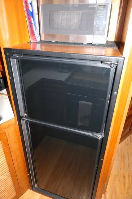 Slide: The Image of 1986 Nova 36 Sundeck interior with black fridge and microwave. - 23