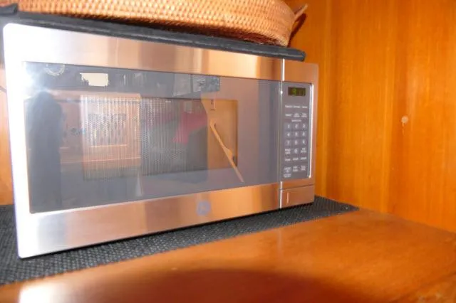 Slide: The Image of Microwave oven inside 1986 Nova 36 SUNDECK, wooden interior background. - 24