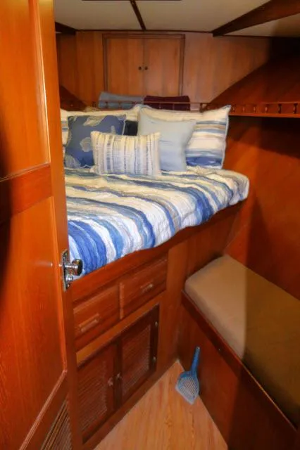 Slide: The Image of Cozy cabin interior of 1986 Nova 36 Sundeck with striped bedding and wooden furnishings. - 27