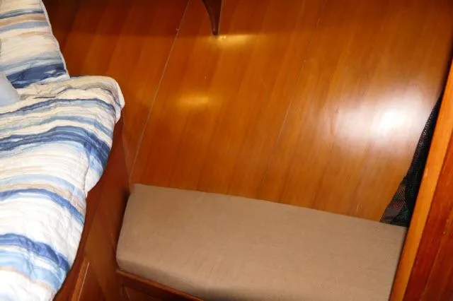 Slide: The Image of Interior of 1986 Nova 36 Sundeck with wooden flooring and striped bedding. - 29
