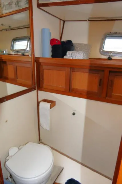 Slide: The Image of 1986 Nova 36 Sundeck yacht bathroom with wooden cabinets and porthole window. - 31