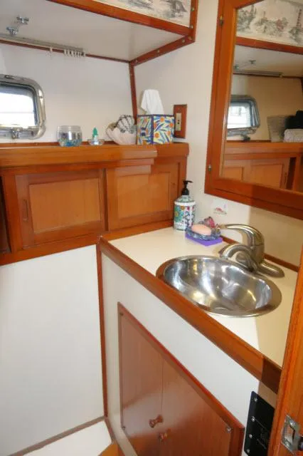 Slide: The Image of 1986 Nova 36 Sundeck bathroom with wooden cabinets and stainless steel sink. - 32