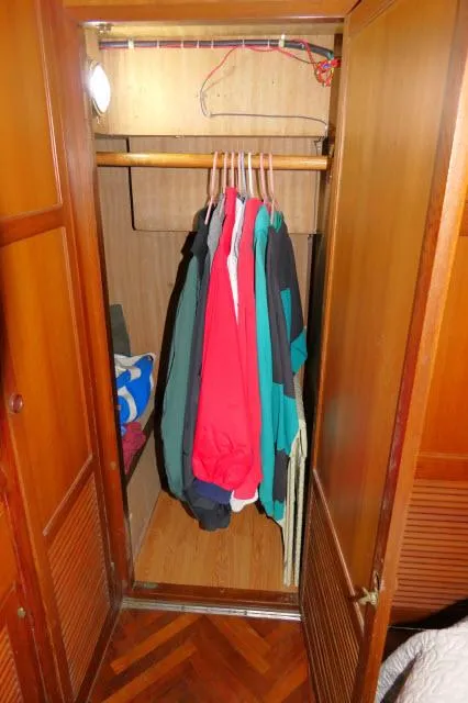 Slide: The Image of Wooden closet with hanging clothes inside a 1986 Nova 36 Sundeck boat. - 39