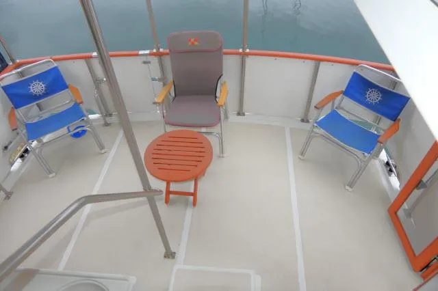 Slide: The Image of 1986 Nova 36 Sundeck boat deck with chairs and table, overlooking calm water. - 47