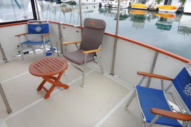 Slide: The Image of 1986 Nova 36 Sundeck yacht with chairs and table on deck, docked at marina. - 48