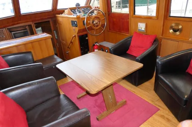 Slide: The Image of Interior of 1986 Nova 36 SUNDECK yacht with wooden table, chairs, and helm. - 5