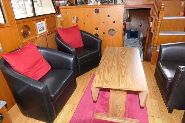 Slide: The Image of Interior of 1986 Nova 36 Sundeck with leather chairs, wooden table, and red accents. - 8