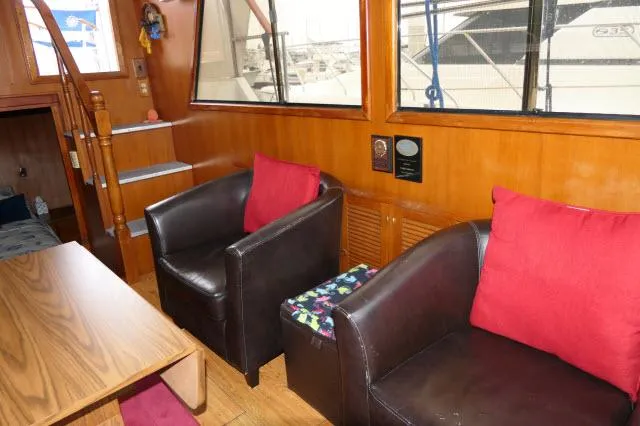 Slide: The Image of Interior of 1986 Nova 36 Sundeck yacht with leather chairs and wooden accents. - 9