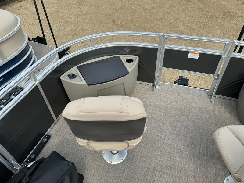 Slide: The Image of 2024 Sun Tracker Fishin' Barge 20 DLX interior with beige seating and fishing station. - 10