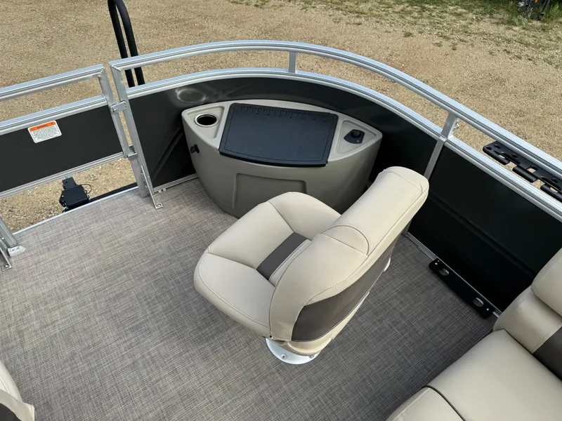Slide: The Image of 2024 Sun Tracker Fishin' Barge 20 DLX interior with beige seating and fishing station. - 9