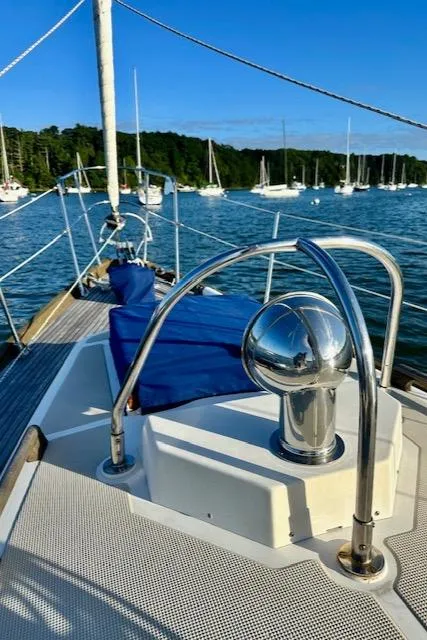 Slide: The Image of 1986 Mason 33 sailboat on calm water with blue skies and forested shoreline. - 10