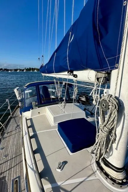 Slide: The Image of 1986 Mason 33 sailboat with blue canvas, docked on a sunny day. - 14