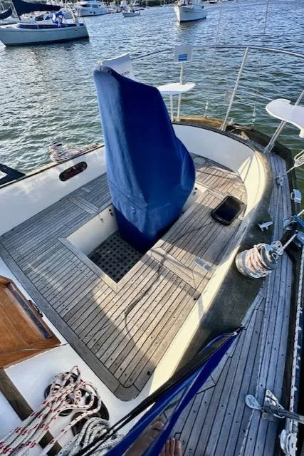 Slide: The Image of 1986 Mason 33 sailboat deck with blue cover, docked by the water. - 15