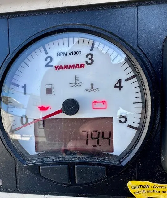 Slide: The Image of Yanmar RPM gauge displaying 79.4, with warning indicators lit. Mason 33, 1986 model. - 28