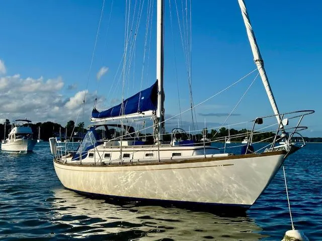Slide: The Image of 1986 Mason 33 sailboat on calm water under a clear blue sky. - 3