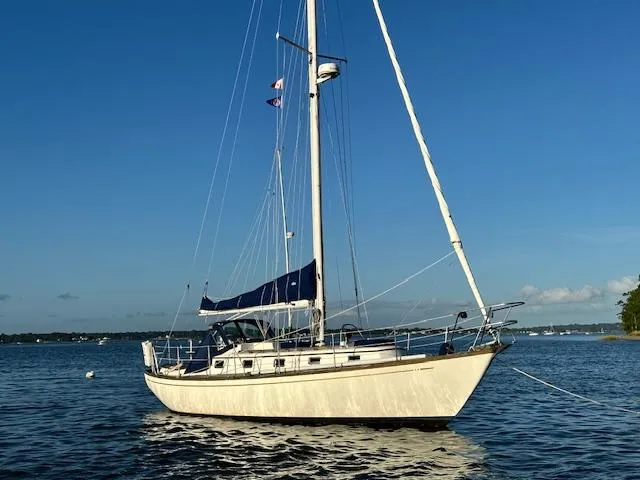 Slide: The Image of 1986 Mason 33 sailboat anchored on calm water under clear blue sky. - 5