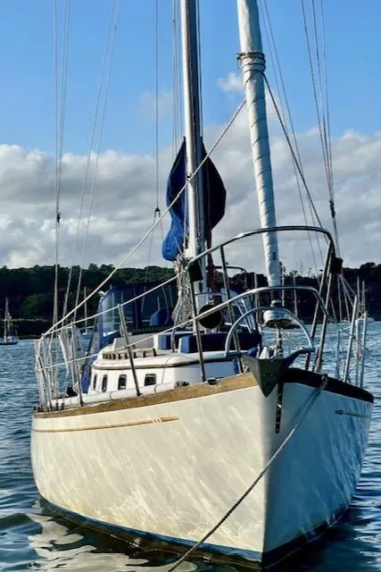 Slide: The Image of 1986 Mason 33 sailboat on calm water with blue sky and distant shoreline. - 9