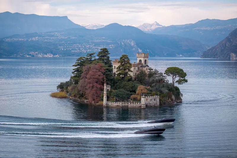 Slide: The Image of Two Riva El-Iseo boats in front of a scenic island backdrop, 2026. - 16