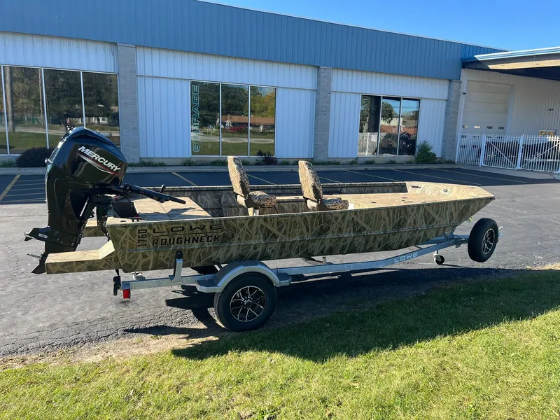 The Image of 2025 Lowe Roughneck 1760 boat on trailer, parked outside a building. - 0