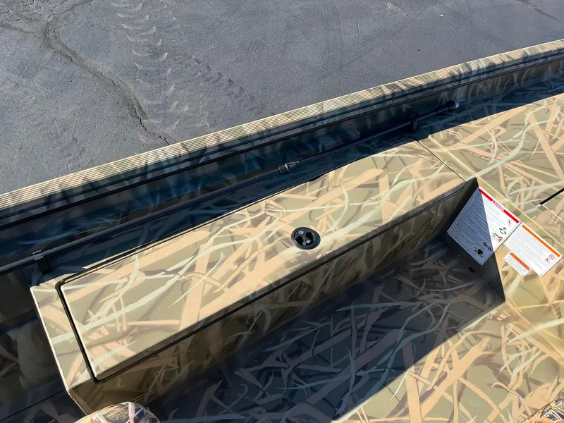 Slide: The Image of 2025 Lowe Roughneck 1760 boat with camouflage pattern and storage compartment. - 12