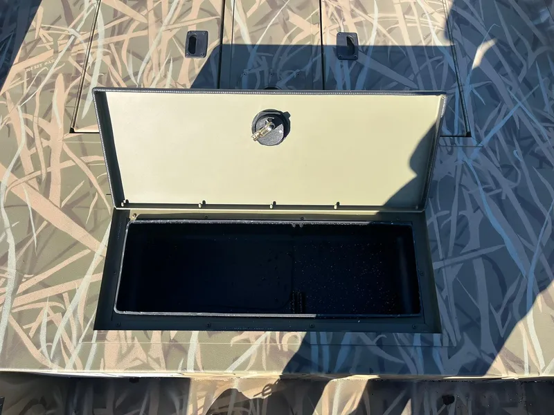 Slide: The Image of 2025 Lowe Roughneck 1760 boat with open storage compartment, camo pattern deck. - 15