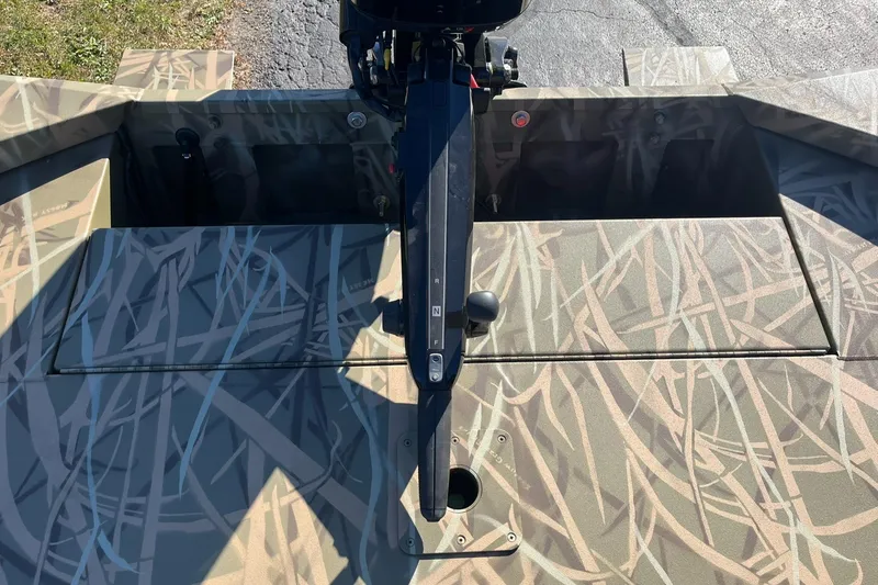 Slide: The Image of 2025 Lowe Roughneck 1760 boat with camouflage pattern and motor, viewed from above. - 20