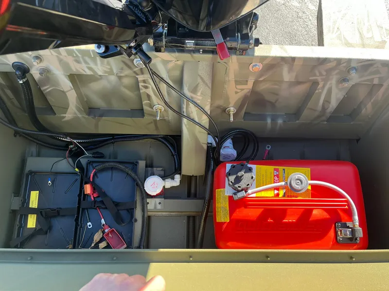 Slide: The Image of 2025 Lowe Roughneck 1760 boat interior with battery and fuel tank setup. - 22