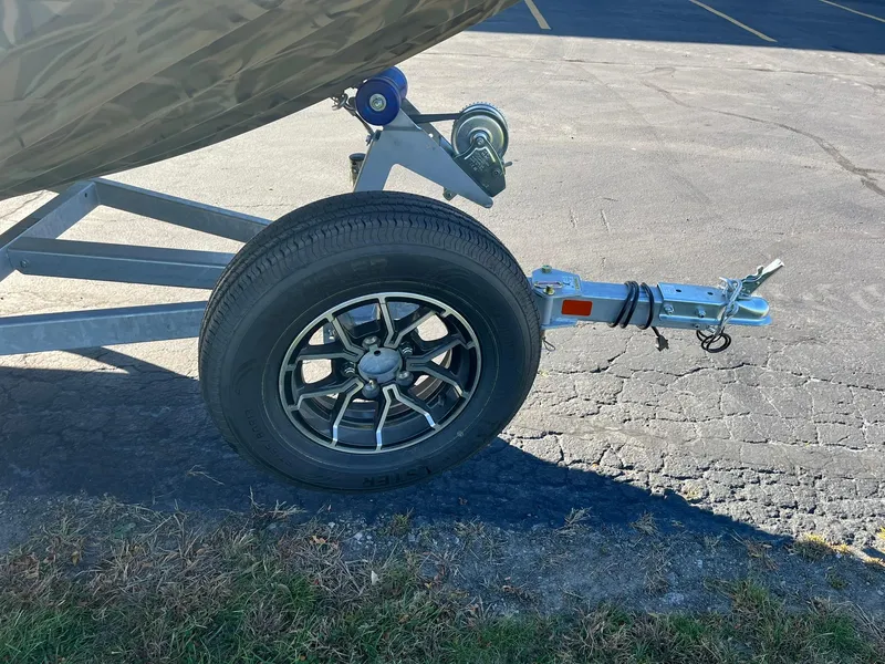 Slide: The Image of Trailer hitch and wheel of 2025 Lowe Roughneck 1760 boat on pavement. - 9