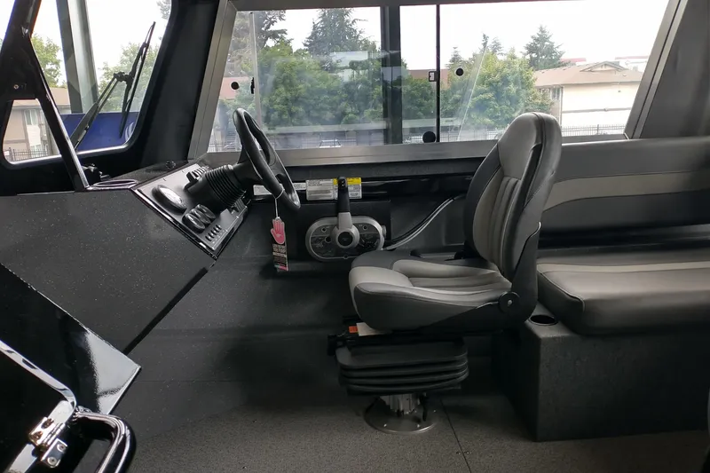 Slide: The Image of Interior of 2024 Spartan 185 Astoria boat, featuring steering wheel and seating. - 10