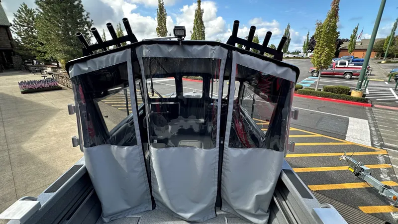 Slide: The Image of 2024 Spartan 184 ASTORIA boat with covered cockpit in a parking lot. - 5