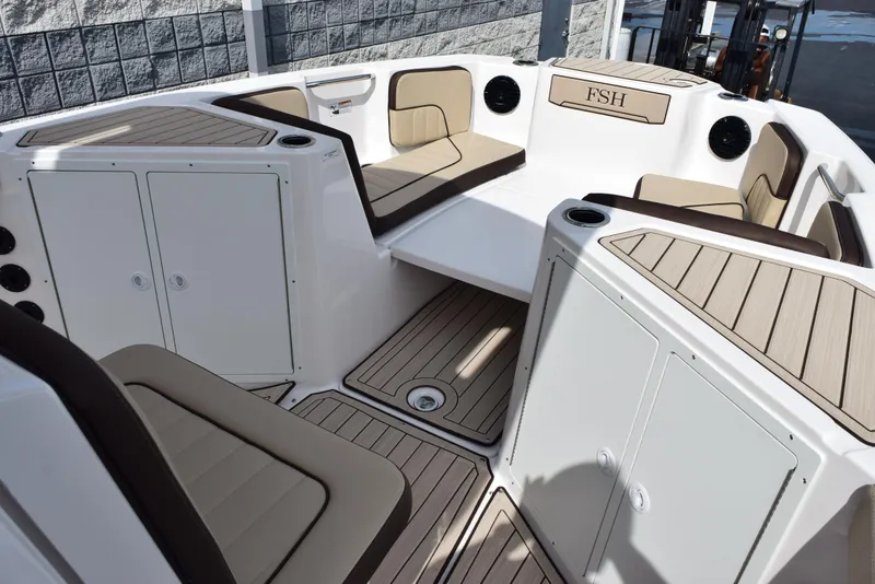Slide: The Image of 2025 Yamaha Boats 222 FSH Sport E interior with cushioned seating and storage compartments. - 10