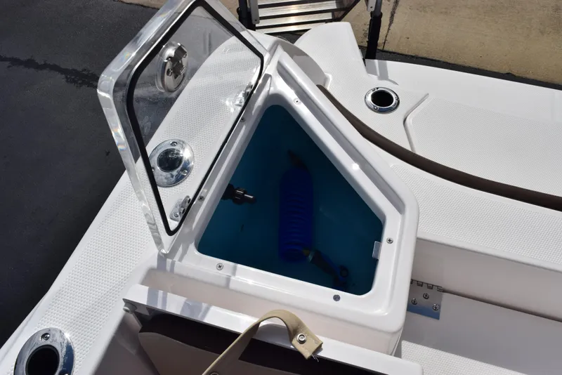 Slide: The Image of 2025 Yamaha Boats 222 FSH Sport E storage compartment with open hatch and blue fender. - 18