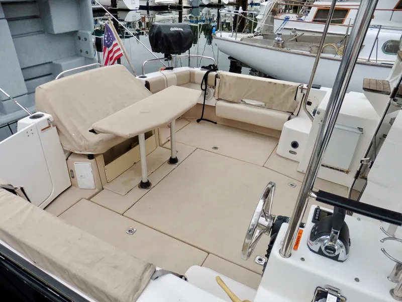 Slide: The Image of 2015 Cutwater 30CB boat interior with seating and table, docked in a marina. - 12