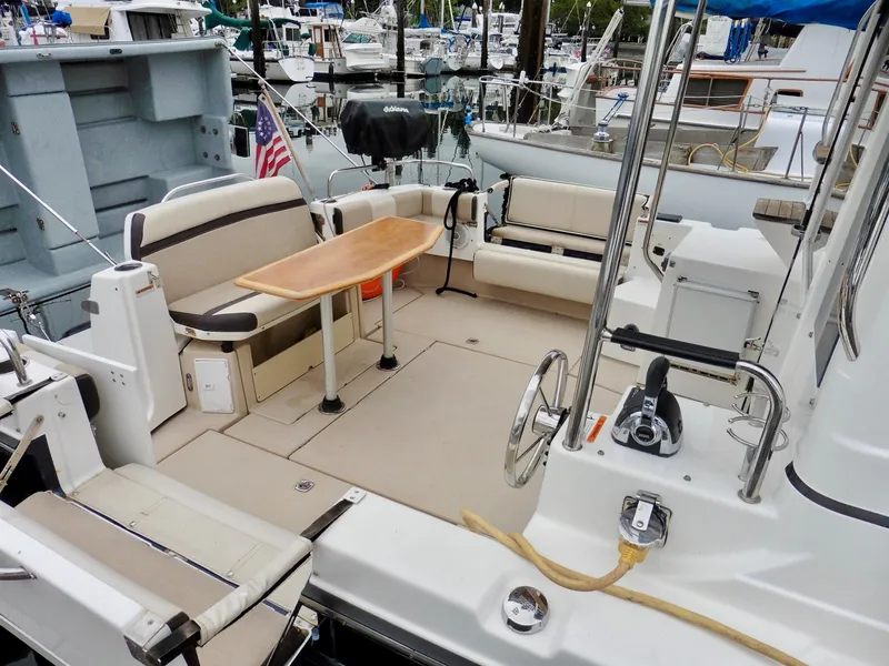 Slide: The Image of 2015 Cutwater 30CB boat with spacious seating and table in marina setting. - 16