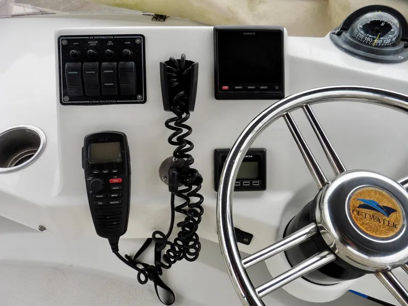 Slide: The Image of Cutwater 30CB 2015 boat dashboard with steering wheel, controls, and communication devices. - 36