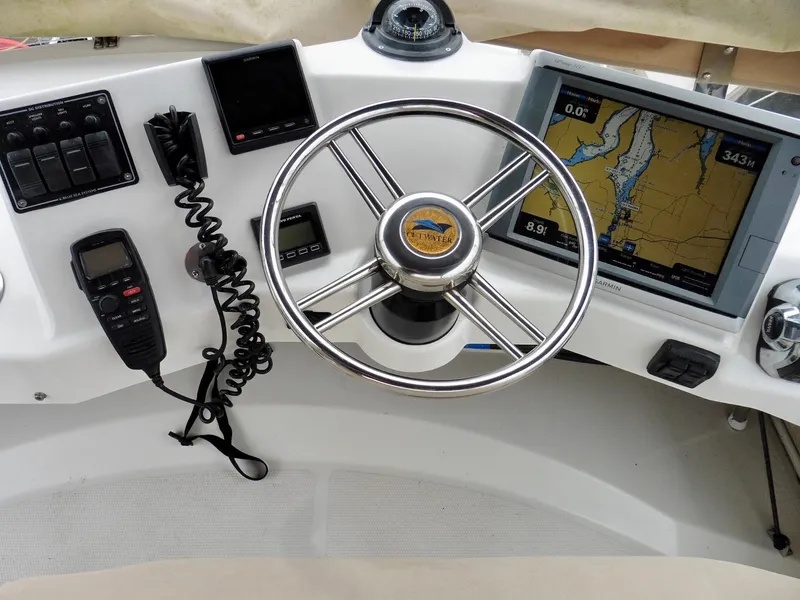 Slide: The Image of Cutwater 30CB 2015 boat helm with GPS, steering wheel, and communication devices. - 39