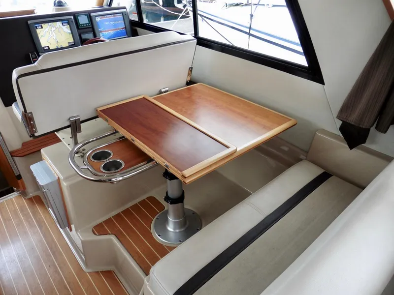Slide: The Image of 2015 Cutwater 30CB interior with wood table, seating, and navigation screens. - 42