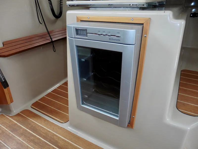 Slide: The Image of 2015 Cutwater 30CB interior with built-in Dometic fridge and wood accents. - 48