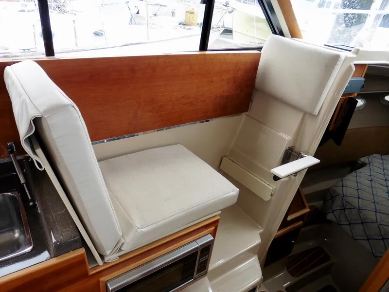 Slide: The Image of Interior of 2015 Cutwater 30CB boat with cushioned seating and wooden accents. - 49