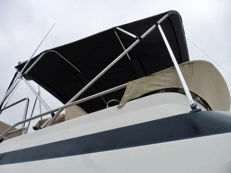 Slide: The Image of 2015 Cutwater 30CB boat with black canopy and railing, viewed from below. - 9