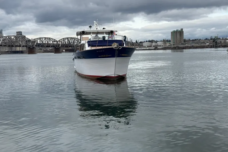 Slide: The Image of 1961 Chris-Craft 55 yacht on calm water with bridge and industrial background. - 10