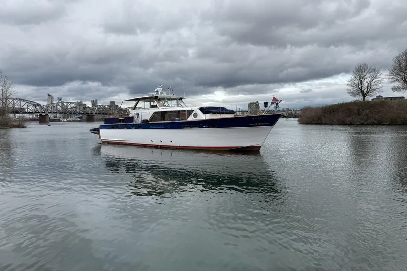 Slide: The Image of 1961 Chris-Craft 55 yacht on a calm river under cloudy skies. - 15