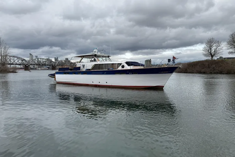 Slide: The Image of 1961 Chris-Craft 55 yacht on a calm river under cloudy skies. - 16