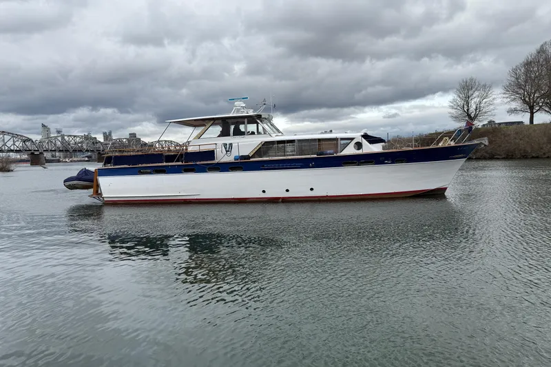 Slide: The Image of 1961 Chris-Craft 55 yacht on a calm river under cloudy skies. - 17