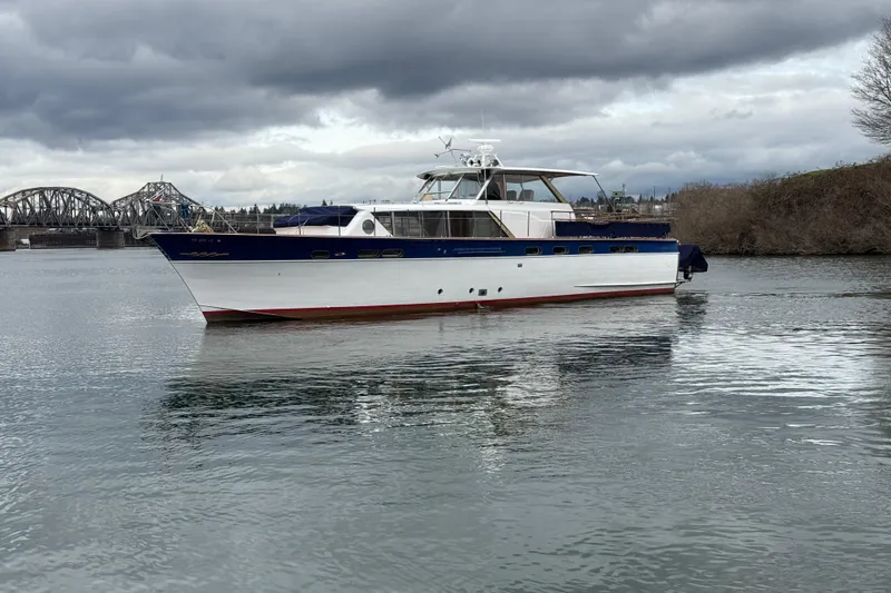 Slide: The Image of 1961 Chris-Craft 55 yacht on a calm river with cloudy skies. - 4