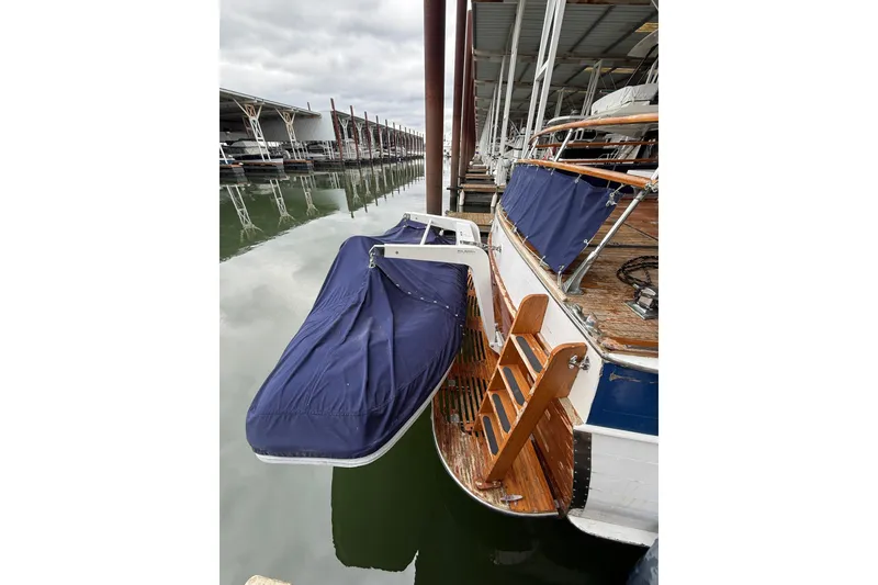 Slide: The Image of 1961 Chris-Craft 55 yacht docked, featuring wooden deck and blue covers. - 40
