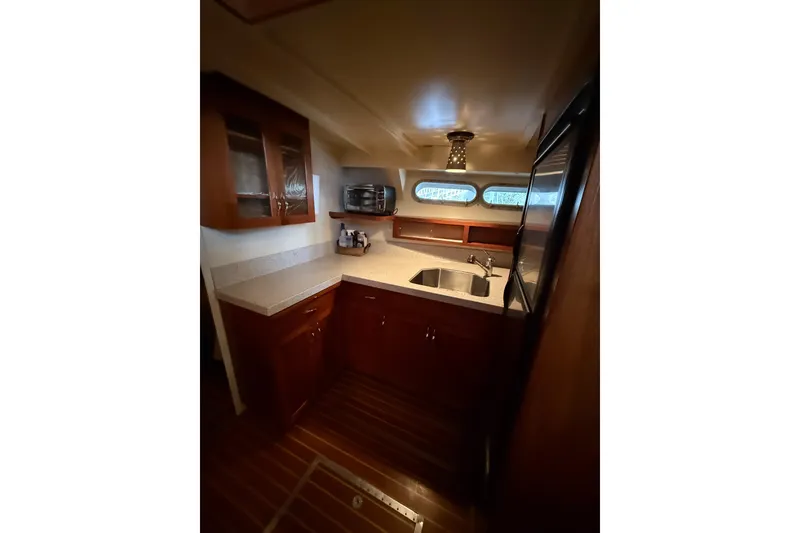 Slide: The Image of 1961 Chris-Craft 55 yacht kitchen with wood cabinetry and modern appliances. - 42