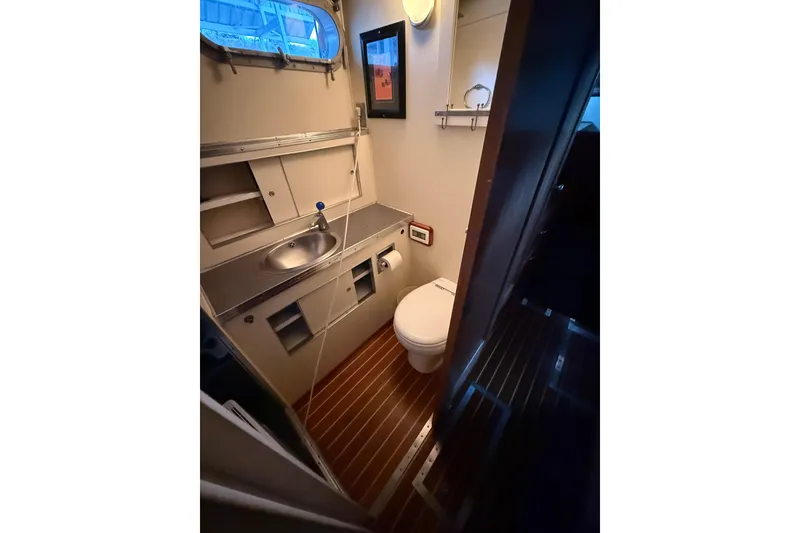 Slide: The Image of 1961 Chris-Craft 55 yacht bathroom with sink, toilet, and wooden flooring. - 49