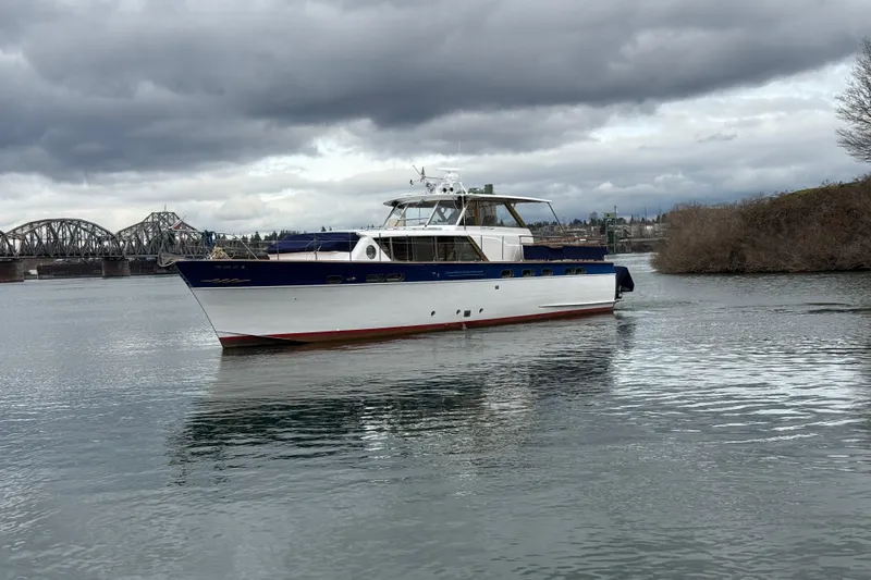Slide: The Image of 1961 Chris-Craft 55 yacht on a calm river under cloudy skies. - 5