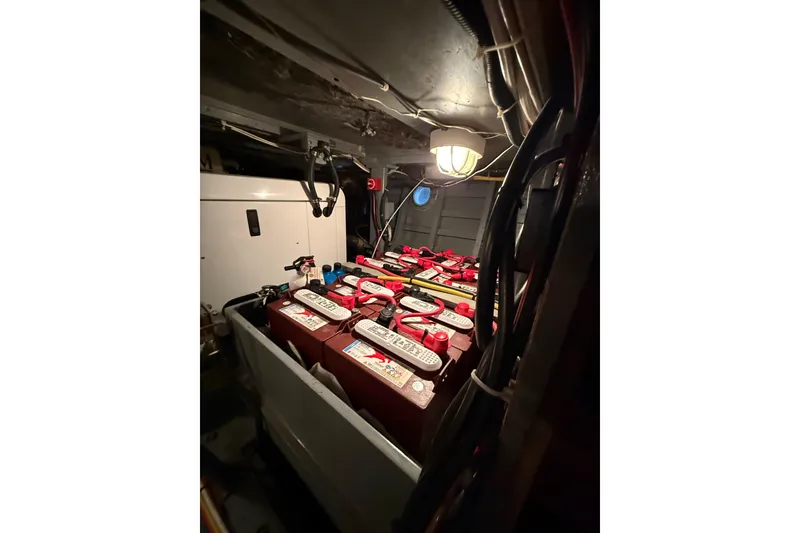 Slide: The Image of Battery compartment of a 1961 Chris-Craft 55 boat, featuring multiple batteries and wiring. - 55
